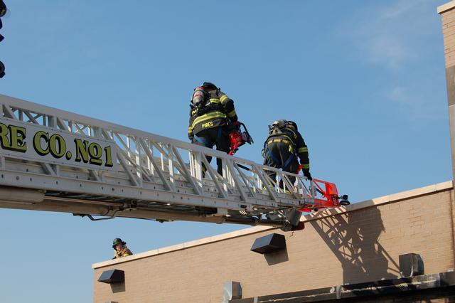 FF Madison and FF/EMT Pires prepare to cut a vent hole at the live burn drill on March 21, 2010.