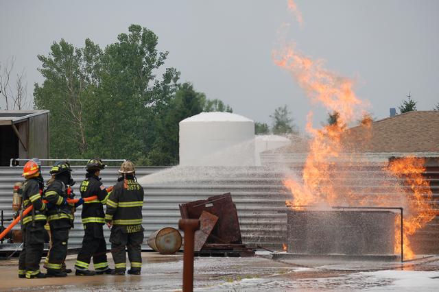 Deputy Chief Bennett instructs FF Karlin on proper foam application techniques.