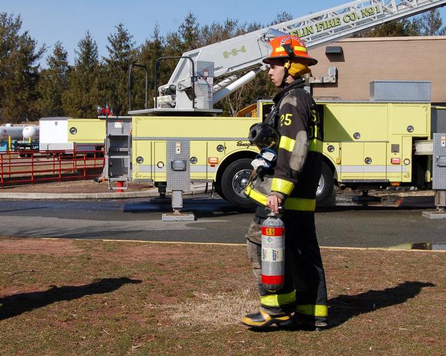 Chris Beglan helps change out SCBA bottles at a live burn drill March 24, 2013.