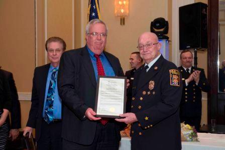 Ex-Chief Roger Stewart receiving a proclamation from Mayor McCormac in recognition of his 50 years of service